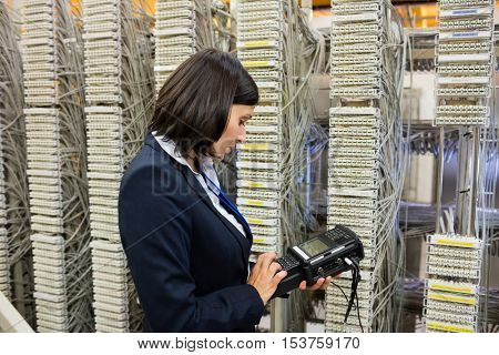 Technician using digital cable analyzer in server room