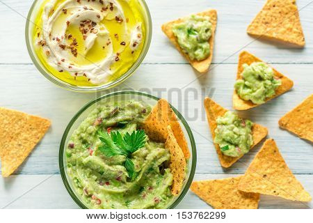 Bowls Of Hummus And Guacamole With Tortilla Chips