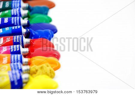 Paint Tubes made out of Tin in Various Colors Squeezed on White Paper Background. Image is composed for design purposes like cards, brochures, magazines, websites