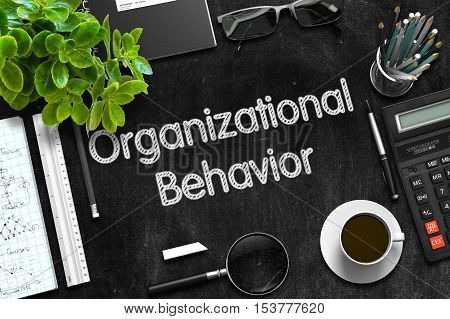 Organizational Behavior. Business Concept Handwritten on Black Chalkboard. Top View Composition with Chalkboard and Office Supplies. 3d Rendering.