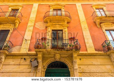 Baroque facede decorated with flowers in Italy. Beautiful travel photo. Colorful background texture with architecture and flowers.