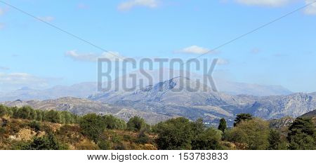 Mount Kedros and distant, misty Mount Ida (Psiloritis), said in mythology to be the birthplace of Zeus, king of the Greek gods, seen from the foothills of Crete's White Mountains, or Lefki Ora