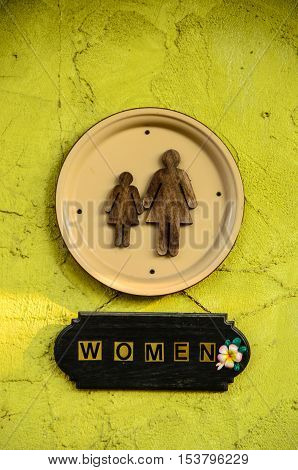 Chic women restroom sign on yellow-green wall