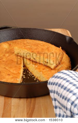 Cornbread ใน Skillet เหล็กกับชิ้นส่วนที่ตัดออก