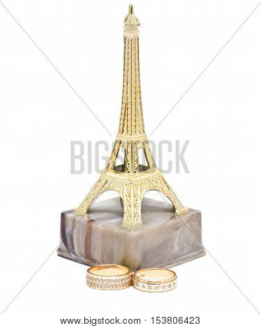 Wedding rings made of gold and the statue Eiffel Tower