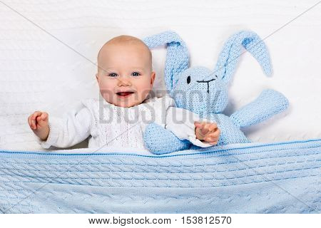Baby Boy Playing With Blue Knitted Bunny Toy