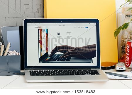 PARIS FRANCE - OCT 28 2016: Apple Computers website on new MacBook Pro Retina with OLED touch bar in a geek creative room showcasing new professional laptop - detail of hands wotking on laptop using the touch bar and the keyboard