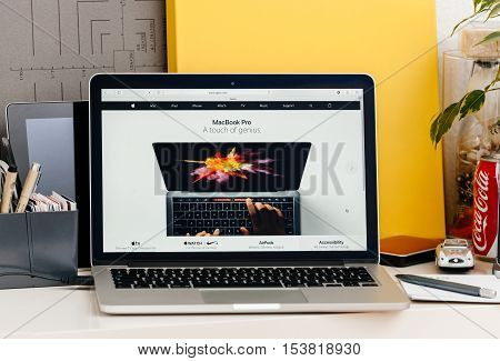 PARIS FRANCE - OCT 28 2016: Apple Computers website on new MacBook Pro Retina with OLED touch bar in a geek creative room showcasing new professional laptop - detail of hands using the new touch bar