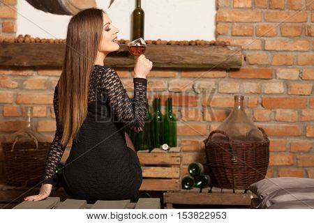 Woman Tasting Wine In Rural Cottage Interior