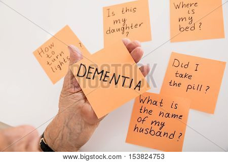 Close-up Of Person's Hand Holding Dementia Sticky Note At Home