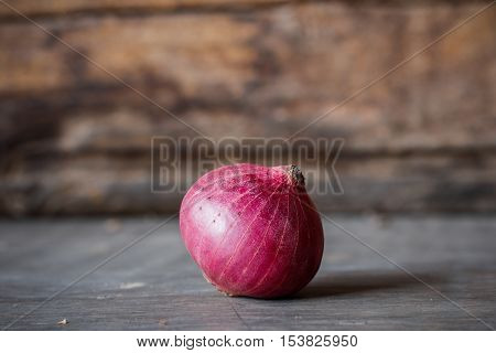 Close-up of fresh red onions on a wooden background