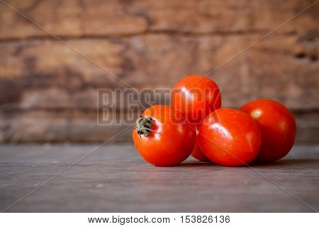 Close-up of fresh red delicious tomatoes on an old wooden table background, Copy space.