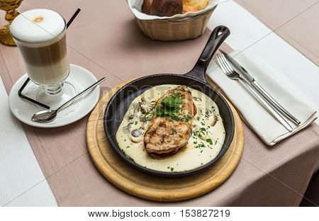 chicken fillet in a creamy mushroom sauce in a frying pan
