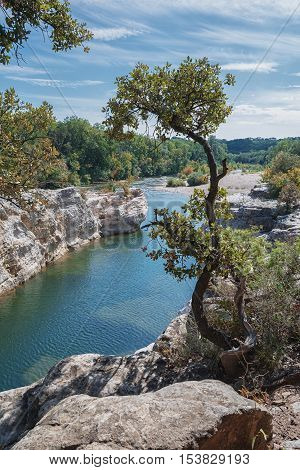 At the foot of the hill on which La Roque sur Cèze in France lies swirl spectacular waterfalls and rapids of the Cascades du Sautadet.