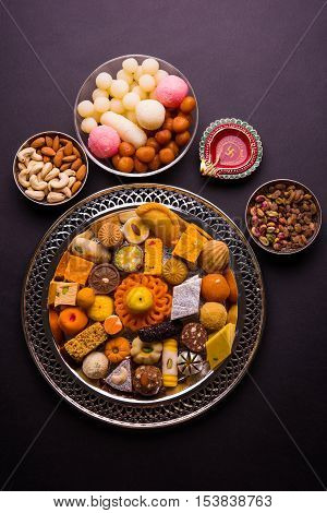 Mix Mithai and diya on diwali over colourful background
