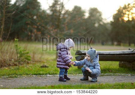 Two sisters playing outdoors on early spring or late autumn