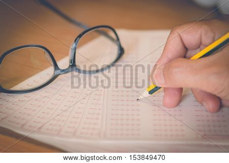 optical form of an examination with pencil and glasses filling a standardized test form