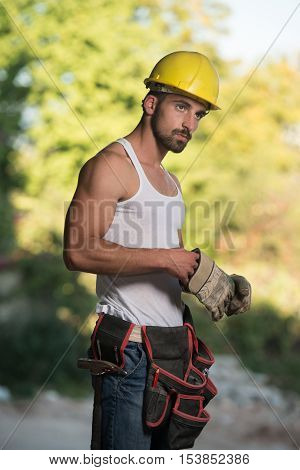 Portrait Of A Worker Takes Off The Gloves