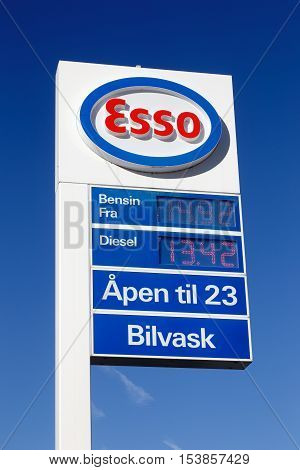 Elverum Norway - October 3 2016: White red and blue advertising sign of the Esso gasoline service station with car wash.including prices and open hours with a blue sky in the background.