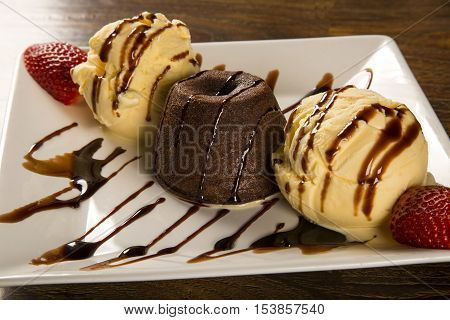 Petit Gateau Dessert With Ice Cream And Strawberry On Wooden Background