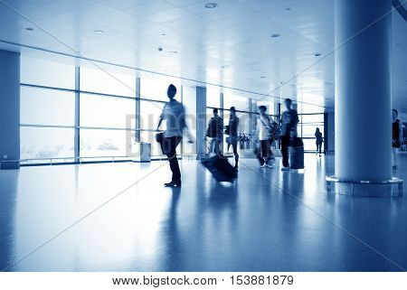 Passengers traveling in the lobby of the airport terminal.