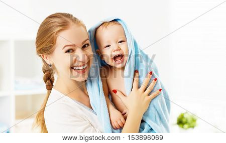 Happy family mother and baby in a blue towel after bathing in the bath