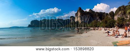 KRABI - JANUARY 20, 2015 : Tourist enjoying a beach walk and sunbathing on a sunny day JANUARY 20, 2015 at Railay Beach in Krabi, Thailand. Railay Beach is a small peninsula with white sand beaches, soaring limestone cliffs, viewpoints, caves and a lagoon