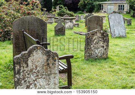 Cirencester UK - August 17 2015: Wooden bench in the churchyard of the Parish Church of St John Baptist in Cirencester.