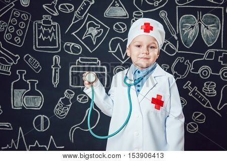 Happy boy playing a doctor holding a sthetoscope - isolated over white