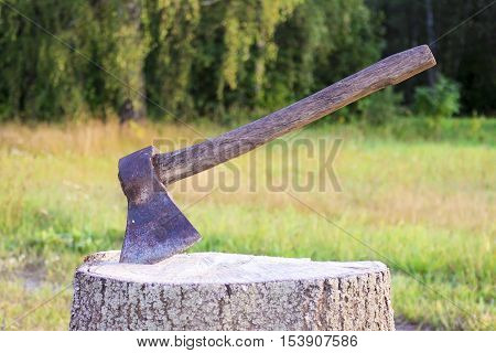 A hatchet on a stump , on a green background.Ax, hatchet, axe.