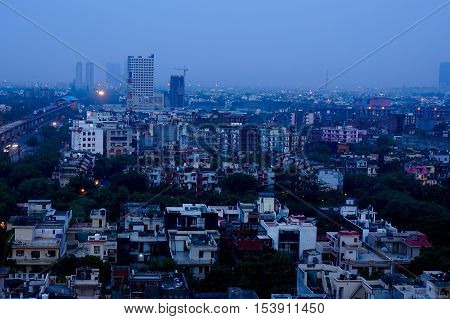 Buildings in Noida at dusk with the lights shining bright. The cityscape of noida is now being modernized with the addition of multiple skyscrapers.