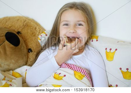 Adorable ill girl eating breakfast in bed