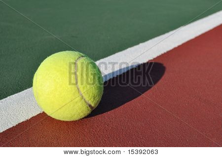 Pelota de tenis amarilla en cancha