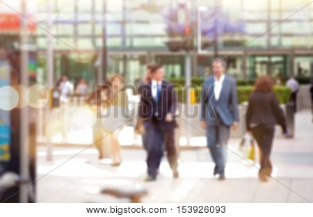 Business people walking in the City, blurred image with lights reflection. Business and modern life concept