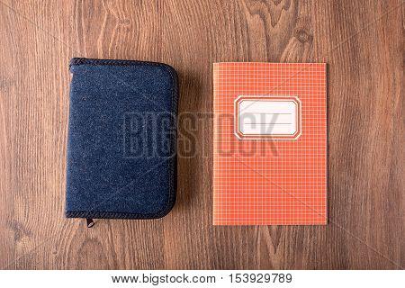 Squared Exercise Book And Pencil Case On Wooden Background