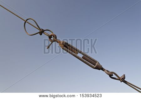Steel turnbuckle holding hook eye with fastening and metal cables