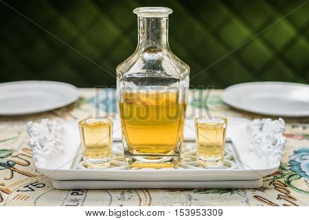 Carafe with honey vodka on white elegant tray