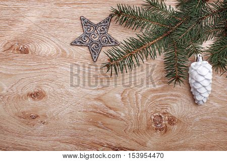 Silver Christmas ornaments and fir tree branch on a rustic wooden background. Xmas card. Happy New Year. Top view with copy space