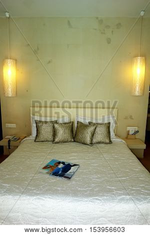 HERAKLION CRETE GREECE - MAY 13 2014: The Interior room with big bed lamps and golden pillows in modern building of luxury class hotel on the Mediterranean coast of Crete May 13 2014 Greece.