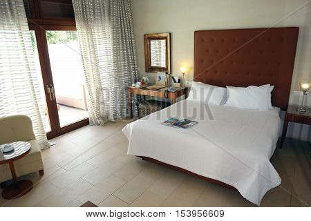 HERAKLION CRETE GREECE - MAY 13 2014: The Interior room with big bed lamps and terrace in modern building of luxury class hotel on the Mediterranean coast of Crete May 13 2014 Greece.