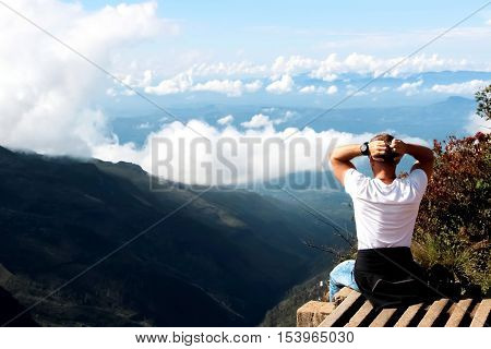 Man relaxes on the edge of the cliff . Plateau 