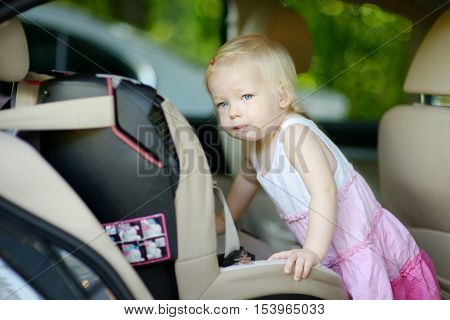 Toddler Girl Getting Into A Car Seat