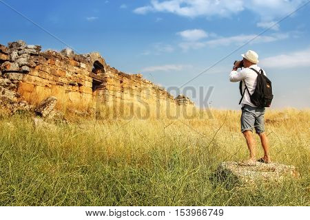Photographing attractions . man photographs the ruins of the ancient city . Hierapolis . Turkey.