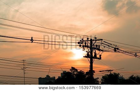 Electricity power plant and city concept - Electric pole in city with evening light and space for text