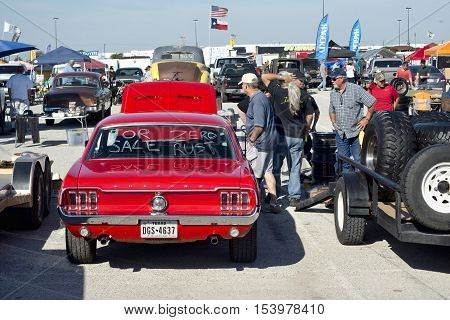 Grand Prairie Texas- Oct.29 2016 Cars for sale at local car swap meet. people looking at a 1966 red Ford Mustang.
