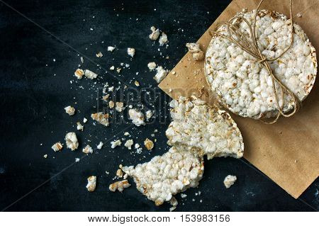 round cereal crispbread tied with rope crumbs on a black metal surface rustic style