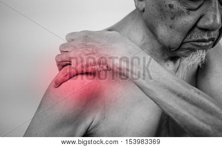 senior man hand holding healthy arm and massaging he shoulder in pain area with red effect