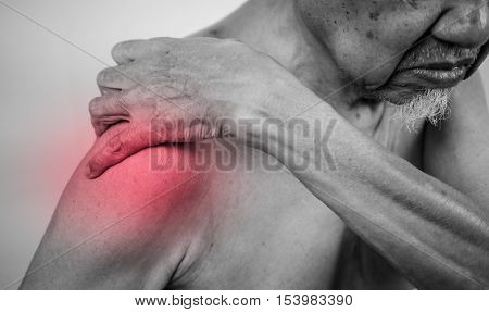 senior man hand holding healthy arm and massaging he shoulder in pain area. red effect