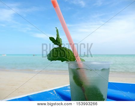 Cocktail on White Sand Beach overlooking turquoise crystal clear waters with Mint