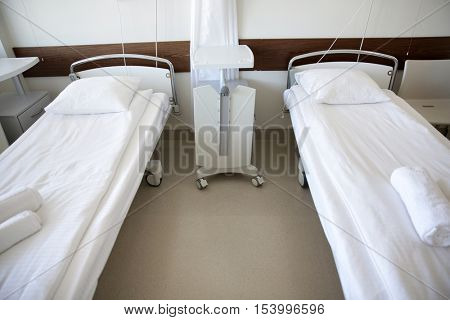 healthcare, medicine and ambulatory concept - hospital ward with clean empty beds